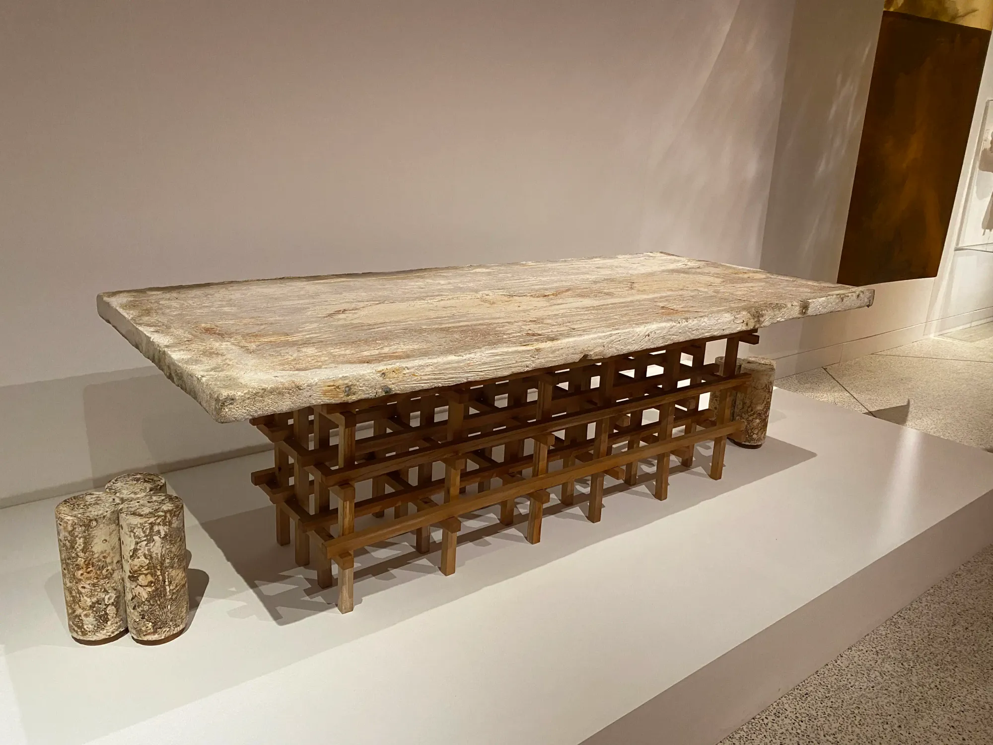 An exhibition display showing a table and two stools made using mycelium. Photo taken at the More Than Human exhibition at the Design Museum.